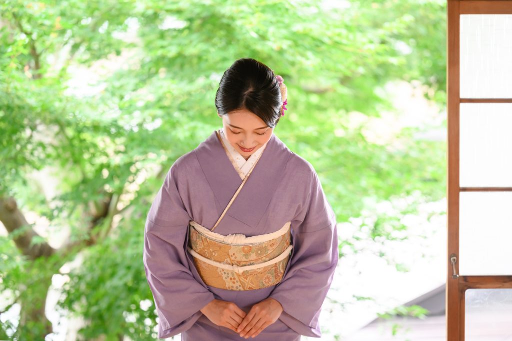 A Japanese women bows to illustrate Omotenashi and the hospitality in customer service