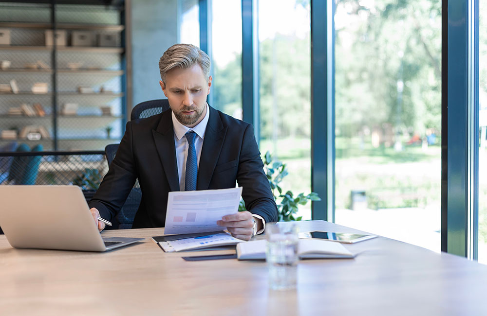 A business man is reading a guide on how to succeed as a CX leader by embracing AI